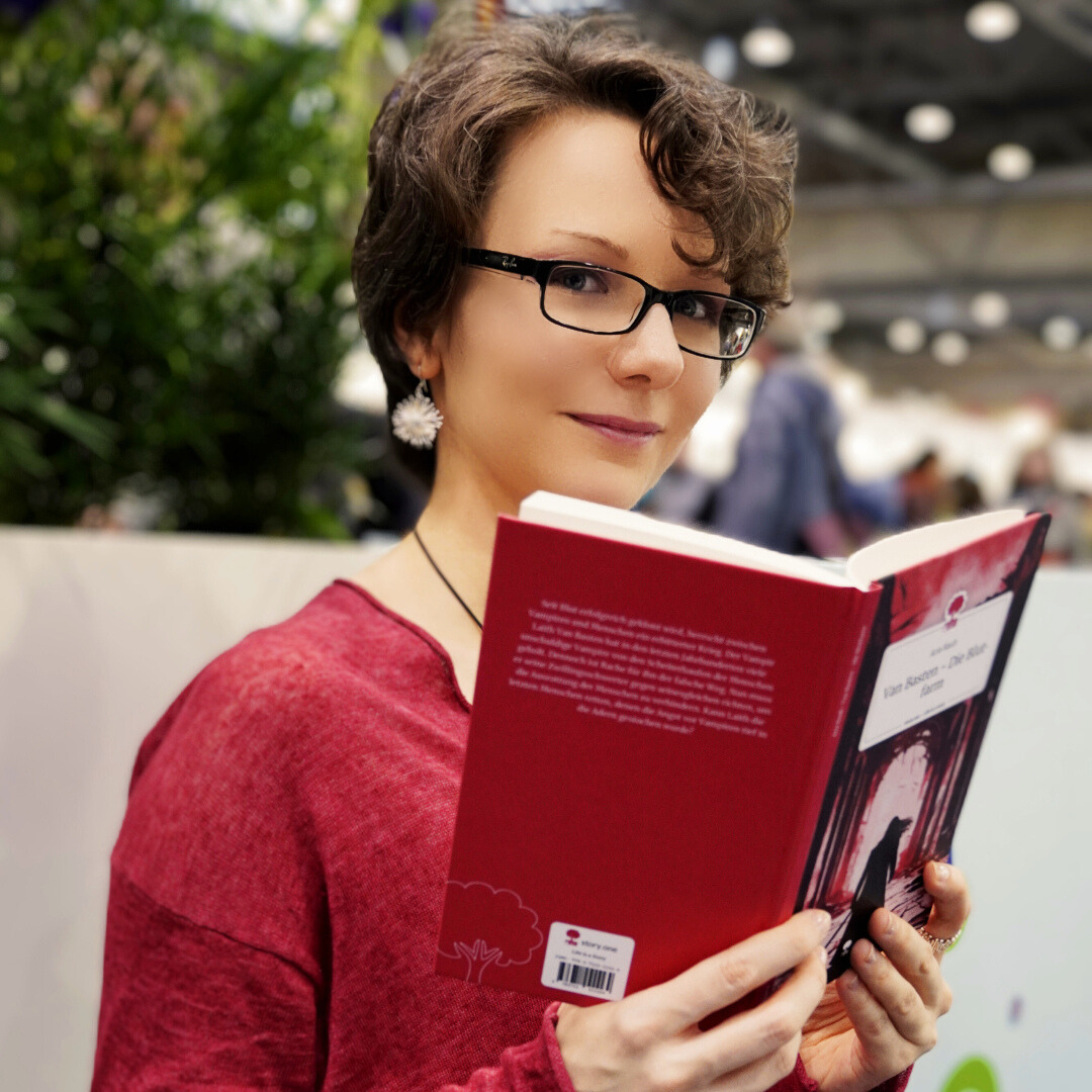 Die Autorin Aria Rauh liest in einem Buch.